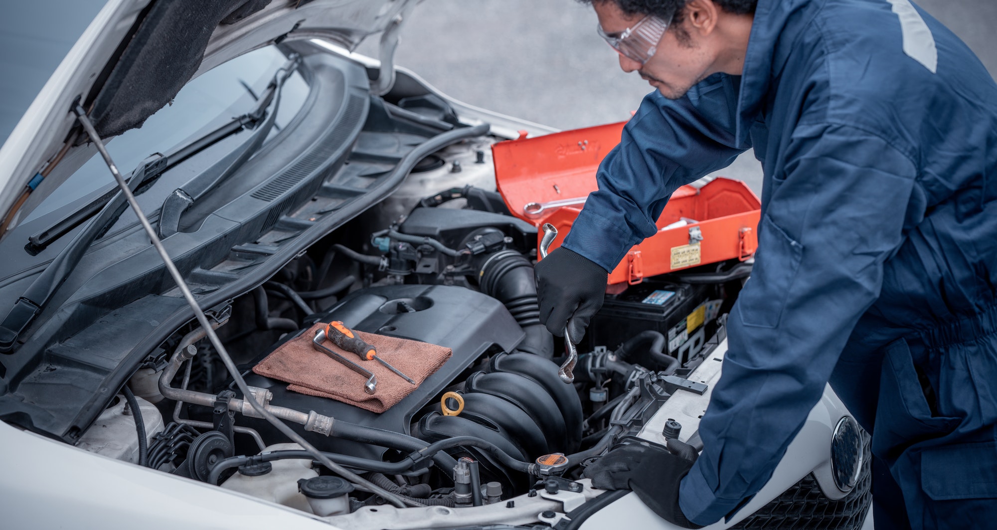 Car mechanic open car hood repairs and check problem system on hand to maintenance and fix