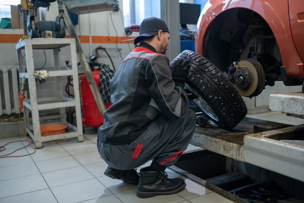 Man Changing Tires in Car Repair Shop